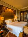 Elegant hotel room in Dubai with ornate decor and plush bedding.