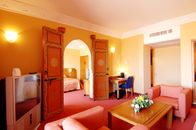 Spacious hotel suite with colorful decor and modern furnishings, offering a warm and inviting atmosphere.